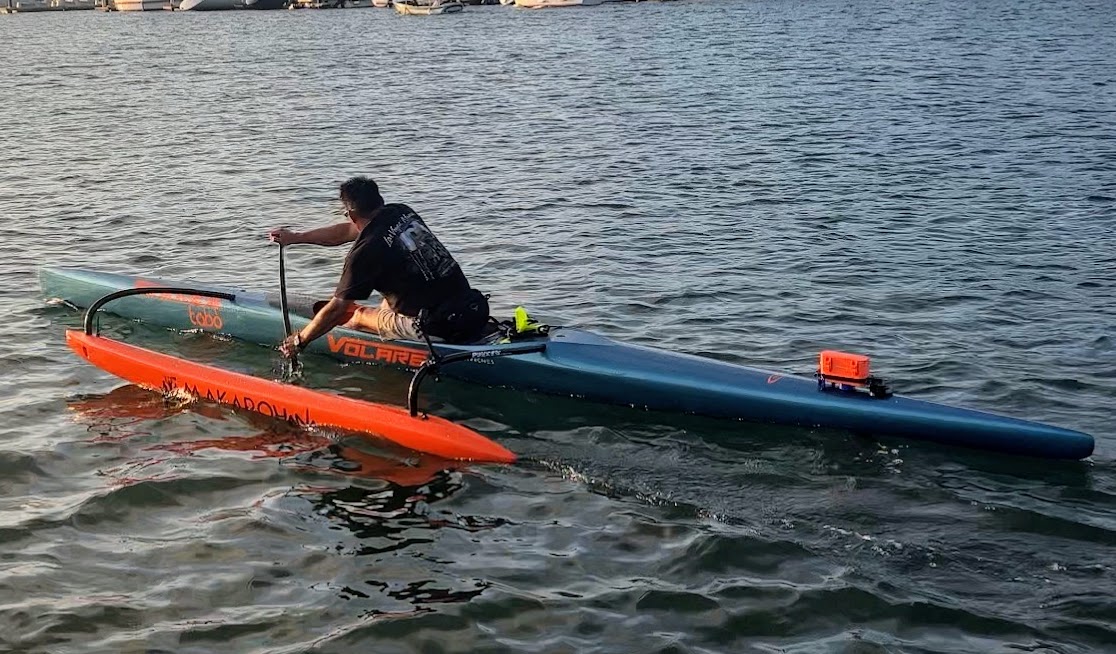 A blind paddler in an outrigger canoe using the CoOP system